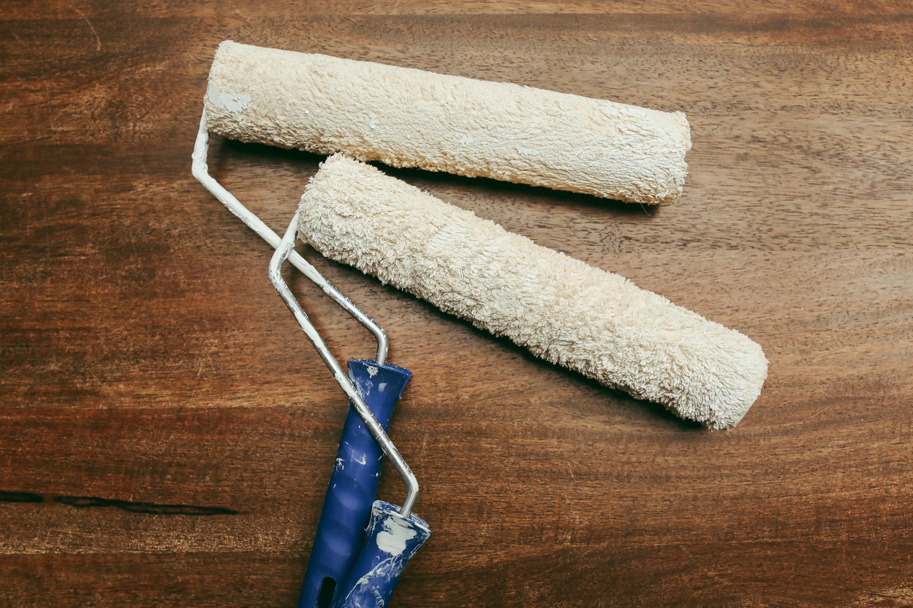 Two paint rollers over a wooden surface, perfect for home renovation concepts in Carlsbad, CA