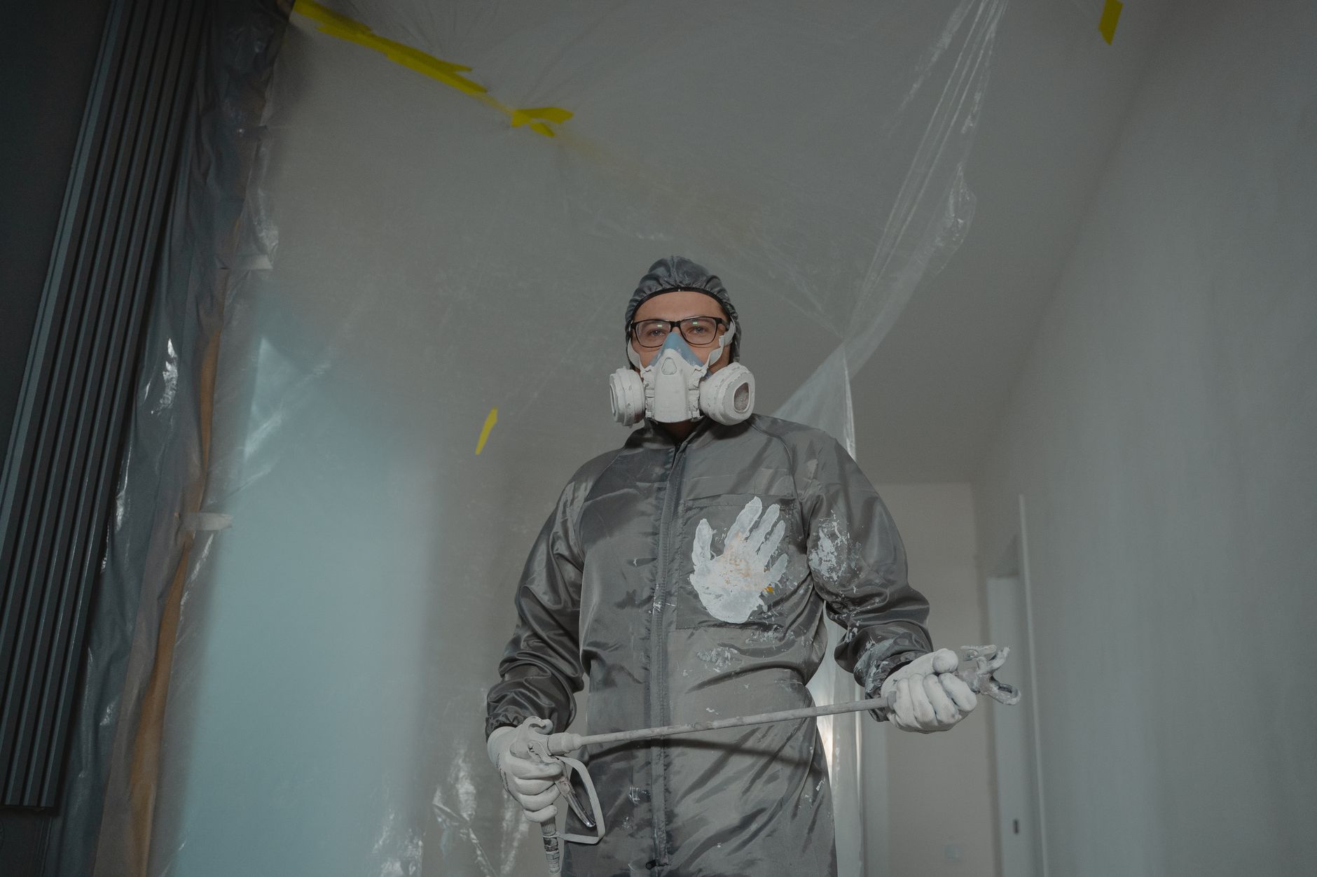Painter in protective suit with mask and goggles preparing for indoor home renovation in Carlsbad, CA